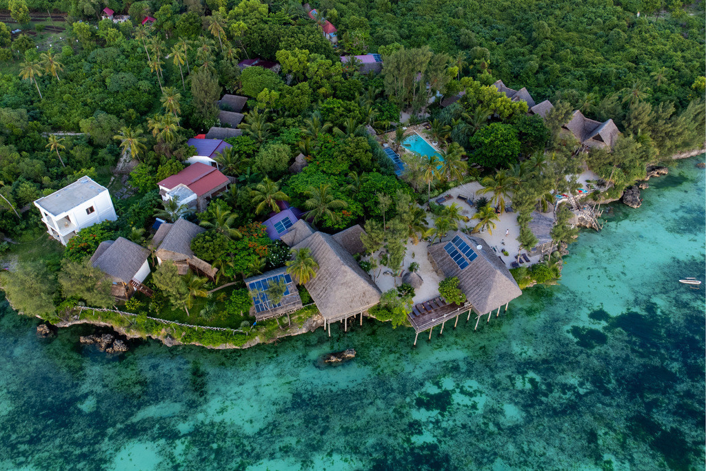 Coastal Bliss in Zanzibar | A stunning aerial view of a tropical retreat in Zanzibar, where lush greenery meets crystal-clear waters.