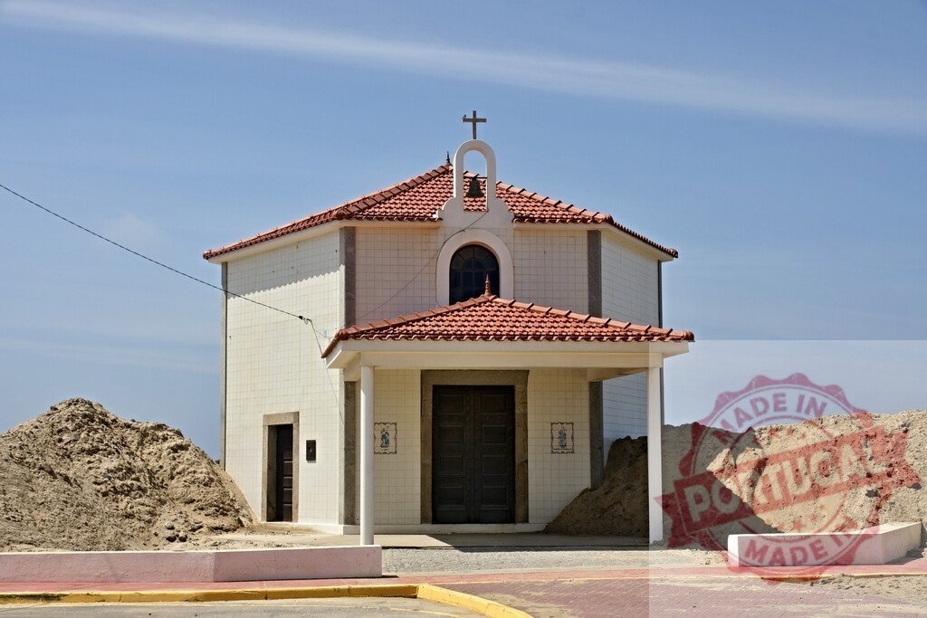 Aveiro Region - Portugal White chapel with cross against blue sky on beach | Small religious building standing among sand mounds on a sunny day - Realized with Pictrs.com