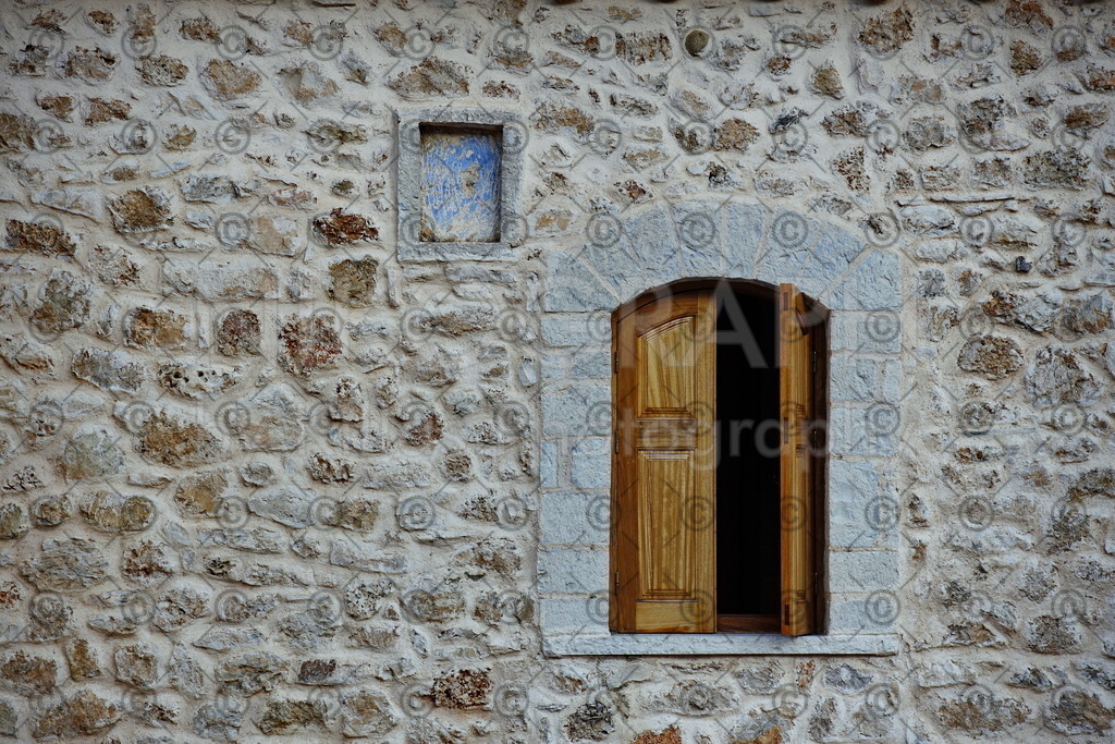 Kloster Giroméri - Iera Moni Giromeriou | Fenster in einer Steinfassade am Kloster Giroméri. Das Kloster „Iera Moni Giromeriou“ liegt in der Präfektur Thesprotia im Nordwesten von Griechenland, rund acht Kilometer von der Stadt Filiates entfernt. Auf der Bergkette Farmakovouni wurde das Kloster Anfang des 14. Jahrhunderts auf einer Höhe von rund 300 Metern gegründet.