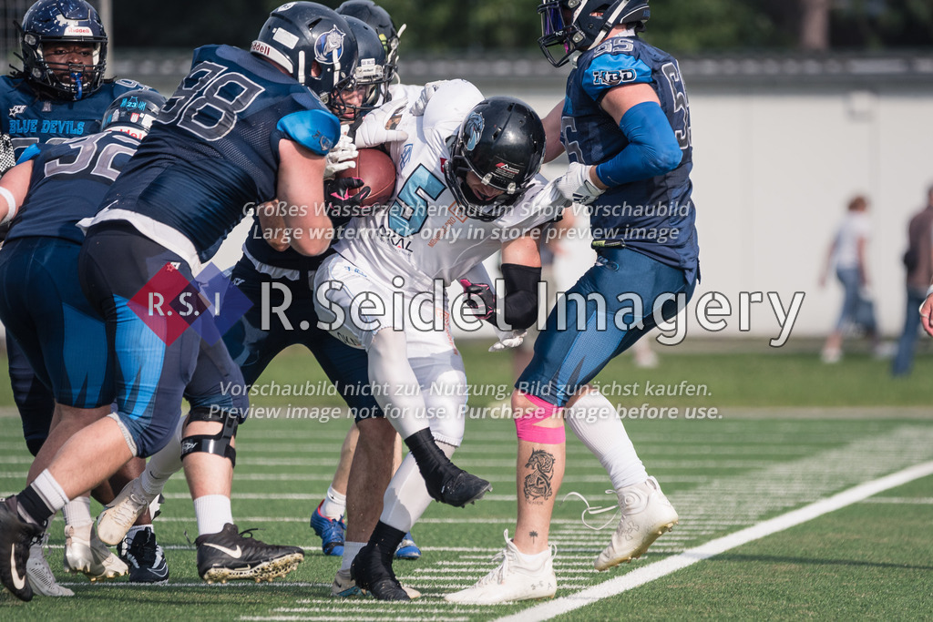 RS-1-131424 | Robin Mergner (#98, Blue Devils, DL), Max Malte Plagge (#22, Blue Devils, hinten) und Alexander Prütz (#55, Blue Devils) schieben Simon Flügel (#5, Ravens) ins Aus.