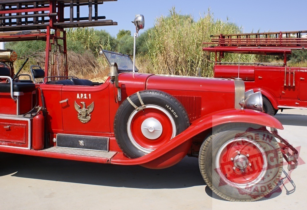 Vintage red fire truck parked outdoors on a sunny day | Red antique fire engine displaying its classic design and equipment, ready for service or a show - Realized with Pictrs.com