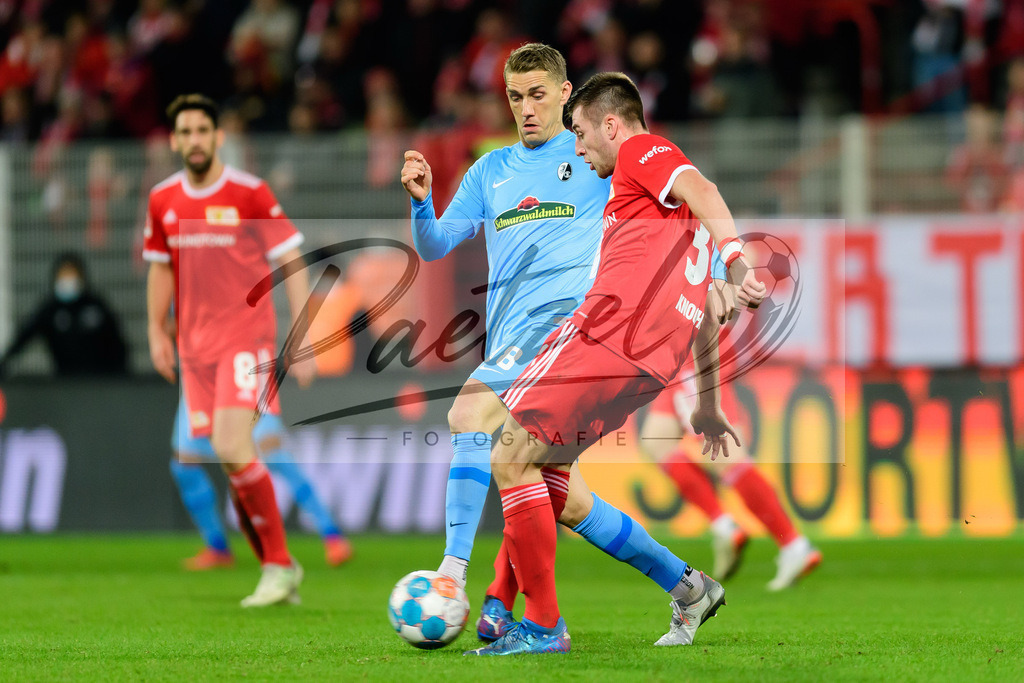 FCUFRE20211215_054 | Fussball, Herren: Nils Petersen (SC Freiburg) und Robin Knoche (1. FC Union Berlin) im Zweikampf bei dem Spiel der 1. Bundesliga zwischen 1. FC Union Berlin und SC Freiburg im Stadion An der Alten Foersterei am 15.12.2021 in Berlin, Deutschland.DFB / DFL REGULATIONS PROHIBIT ANY USE OF PHOTOGRAPHS AS IMAGE SEQUENCES AND/OR QUASI-VIDEO. - Realisiert mit Pictrs.com