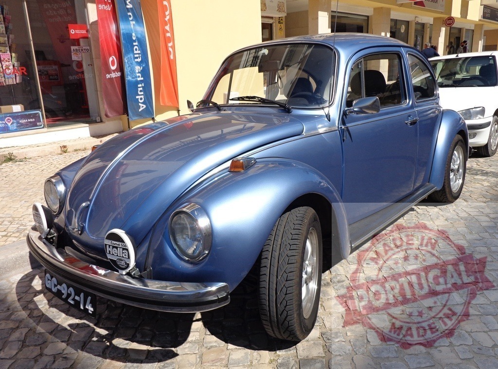 Shiny light blue Volkswagen Beetle parked on cobblestone street | Classic Volkswagen Beetle parked on a cobblestone street, shining under the sunlight - Realisiert mit Pictrs.com