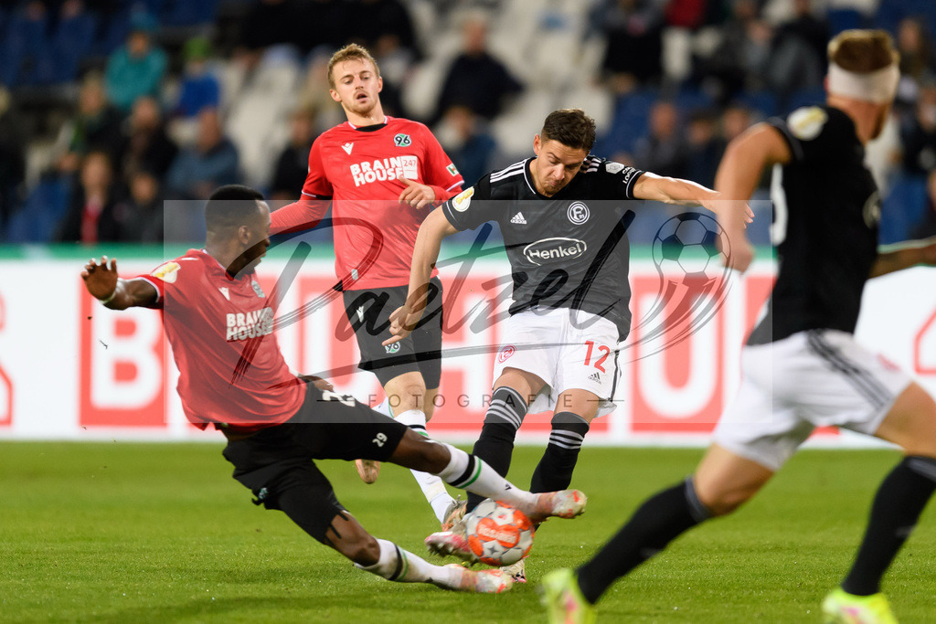 H96DUS20211027_057 | Fussball, Herren: Gael Ondoua (Hannover 96) und Kristoffer Peterson (Fortuna Duesseldorf) im Zweikampf bei dem Spiel der 2. Runde im DFB-Pokal zwischen Hannover 96 und Fortuna Duesseldorf in der HDI-Arena am 27.10.2021 in Hannover, Deutschland.DFB / DFL REGULATIONS PROHIBIT ANY USE OF PHOTOGRAPHS AS IMAGE SEQUENCES AND/OR QUASI-VIDEO. - Realisiert mit Pictrs.com