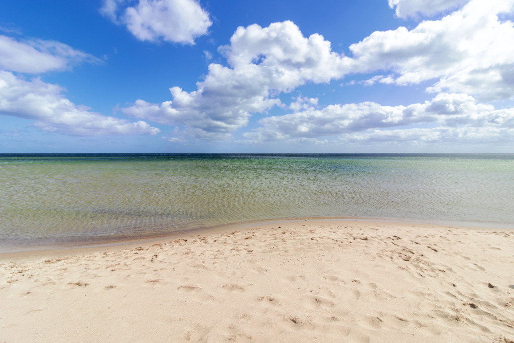 Wandbild: Sand und Wellen – Küstenidylle pur | Sanfte Farben und eine beruhigende Küstenlandschaft – dieses Wandbild vermittelt die entspannte Atmosphäre eines Sommertages am Weidefelder Strand. Die ruhige Bildkomposition mit dem weichen Sand und dem klaren Wasser schafft eine offene und harmonische Raumwirkung.  - Realisiert mit Pictrs.com