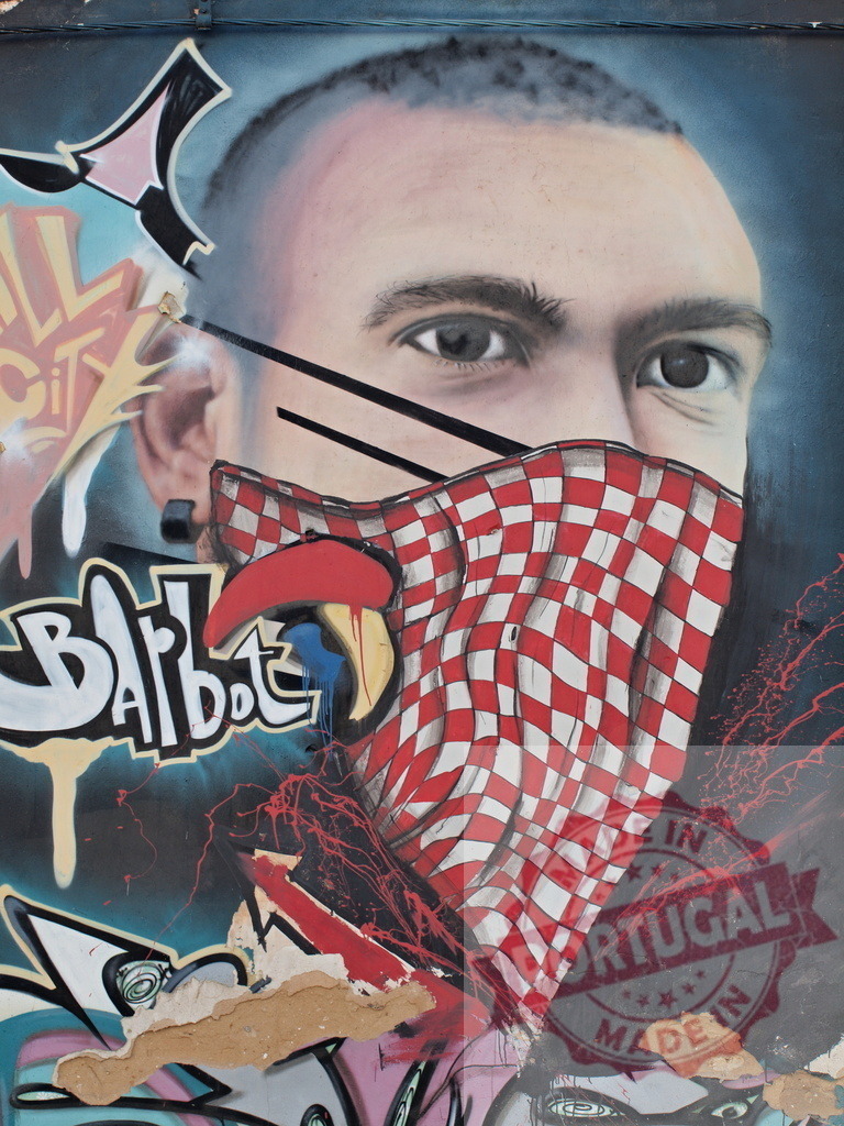 Graffiti portrait of a young man wearing a red and white checkered bandana | Close-up of urban art depicting a young man with a bandana covering the lower part of his face, blending portraiture with vibrant graffiti elements - Realized with Pictrs.com
