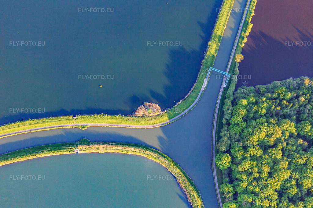 Vue aérienne: Intersection des deux canaux Rhin-Marne et Canal des Houllères de la Sarre dans les lacs du Petit Étang et du Grand Ruisseau avec un passage pour cyclistes et piétons à Gondrexange dans le département Moselle, France. Photo: IMG_146168.jpg prise le 01/05/2025 par Werner Riehm/FLY-FOTO.eu – Résolution de l'original: 5472 x 3648 px