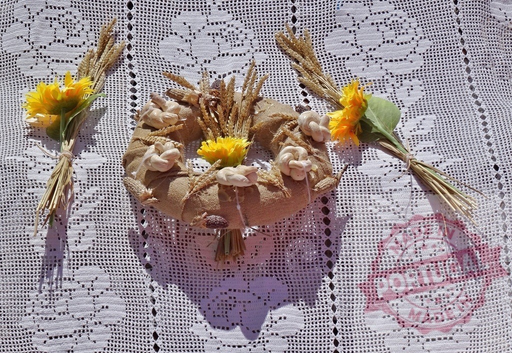 Rustic harvest wreath with bread knots and wheat | Burlap wreath decorated with wheat, sunflowers, and bread knots on a lace tablecloth - Realized with Pictrs.com