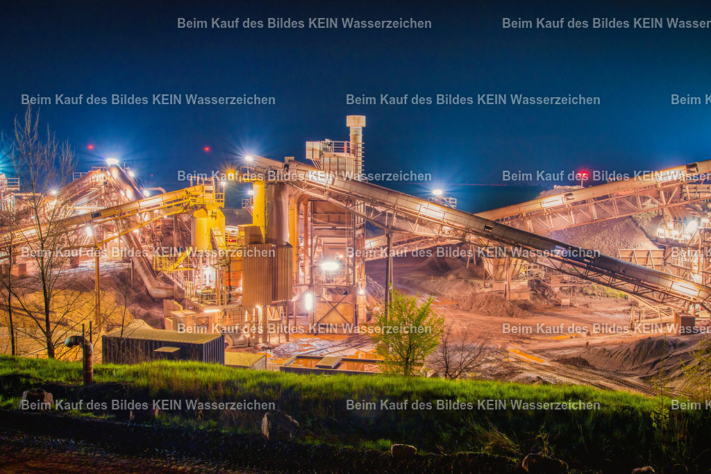 Mammendorf bei Nacht-2630 | Das Foto zeigt die Förderanlage des Steinbruchs Mammendorf bei Nacht als Langzeitbelichtung. Förderbänder, Brecher und Verladeeinrichtungen bilden ein komplexes System zur Aufbereitung des gewonnenen Gesteins. Durch die nächtliche Beleuchtung und die lange Belichtungszeit werden die technischen Strukturen der Anlage eindrucksvoll hervorgehoben und verleihen dem Industriebau eine außergewöhnliche Wirkung.Die Förderanlage verarbeitet das im Steinbruch abgebaute Gestein in mehreren Arbeitsschritten. Nach dem Brechen wird das Material über kilometerlange Förderbänder zu den einzelnen Aufbereitungsstufen transportiert, dort nach Korngrößen sortiert und anschließend für den Weitertransport bereitgestellt. Moderne Förderanlagen erreichen dabei Durchsatzleistungen von mehreren hundert Tonnen Gestein pro Stunde und arbeiten weitgehend automatisiert. Sie bilden das technische Herzstück jedes Steinbruchbetriebs.Die Aufnahme entstand als Langzeitbelichtung des Lichtkunstfotografen Daniel Lehmann. Während der mehrsekündigen Belichtungszeit werden die markanten Stahlkonstruktionen, Förderbänder und technischen Anlagen eindrucksvoll inszeniert. Das Zusammenspiel aus moderner Fördertechnik, künstlichem Licht und fotografischer Langzeitbelichtung macht das Bild zu einer außergewöhnlichen Dokumentation industrieller Ingenieurtechnik. - Realisiert mit Pictrs.com
