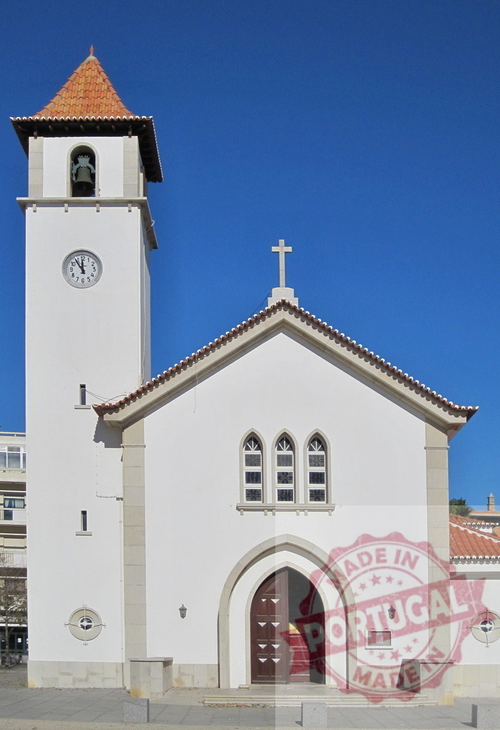 White church building with bell tower and cross under blue sky. Algarve - Silves | White church building featuring a bell tower and cross, displaying religious architecture - Realisiert mit Pictrs.com