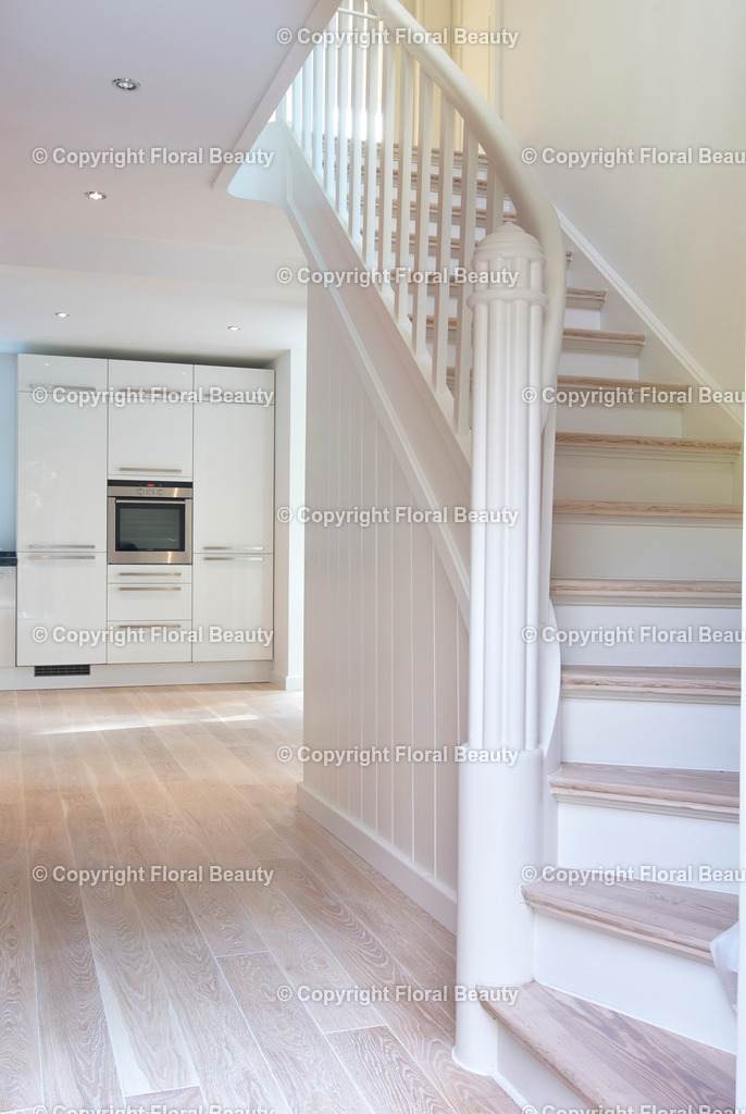 Umbau eines Rotklinkerhauses | Holztreppe in renoviertem Haus mit Dielenboden und Blick auf die Küche - Realisiert mit Pictrs.com