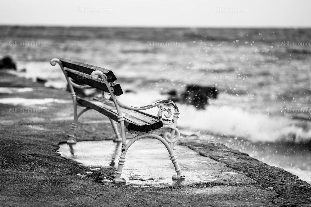Bank am Meer SW | Schwarz-weißes Fotokunstwerk: Eine einsame Bank mit Blick aufs Meer. Zeitlos, still und voller Tiefe – ideal als Kunstdruck für Räume mit Charakter, Melancholie und klarer, reduzierter Ästhetik. - Realisiert mit Pictrs.com