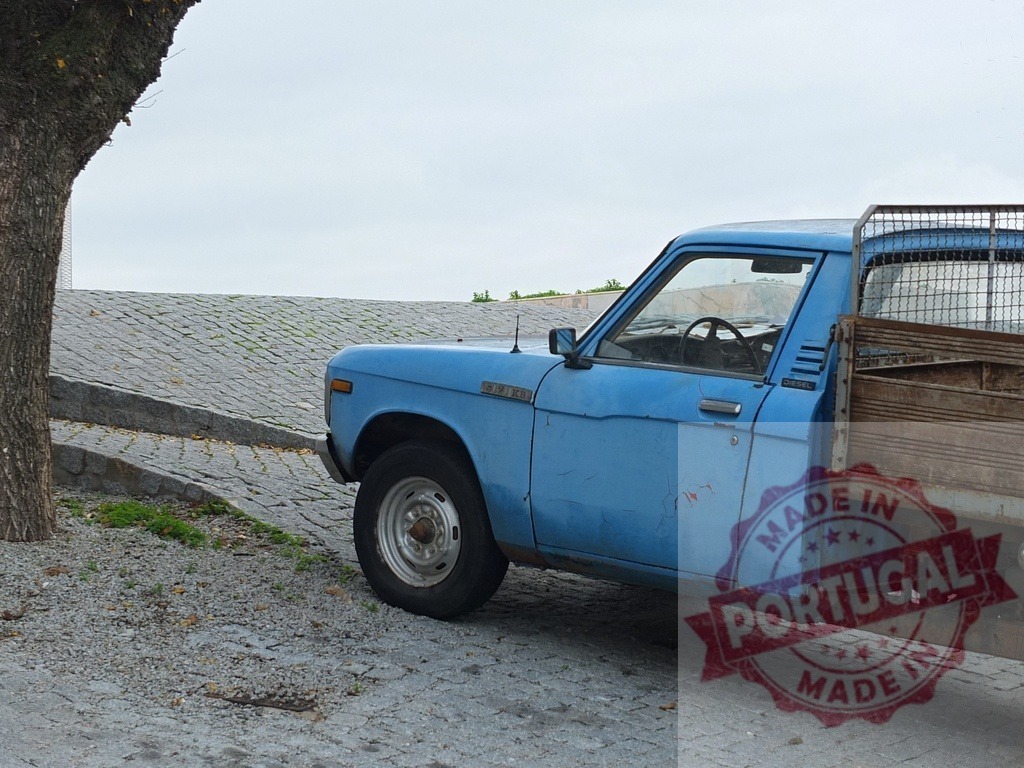 Old blue pickup truck parked on cobblestone street | Blue vintage pickup truck parked next to a tree on a cobblestone street during the day - Realisiert mit Pictrs.com