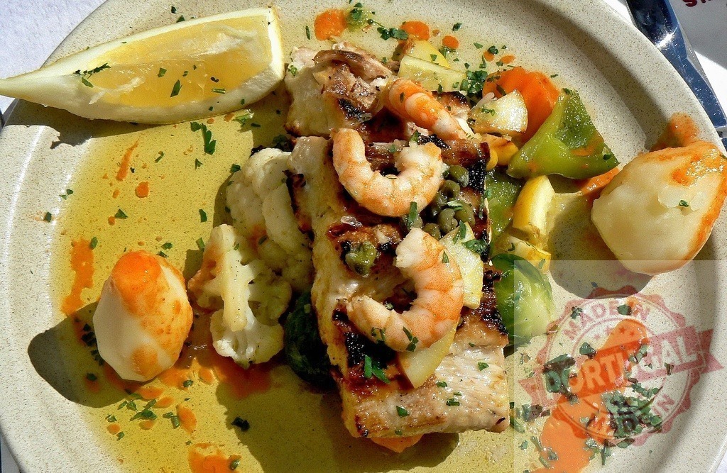 Seafood meal serving grilled fish shrimp vegetables lemon | Seafood plate featuring grilled fish fillet topped with shrimp, vegetables, and lemon - Realized with Pictrs.com