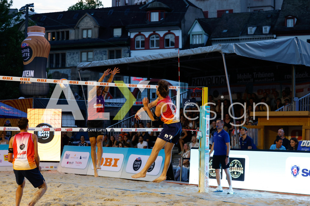 Obi BeachTour 2026 - Basel | BASEL, SWITZERLAND - JULY 17: LUC EMANUEL FLÜCKIGER (SUI) attack / spike against DANIEL ALLEMANN (SUI) block during the Obi BeachTour 2026 match between DILLIER / FLÜCKIGER (SUI) and ALLEMANN / LEFFLER (SUI) at Barfüsserplatz on July 17, 2026 in Basel, Switzerland. - Realisiert mit Pictrs.com