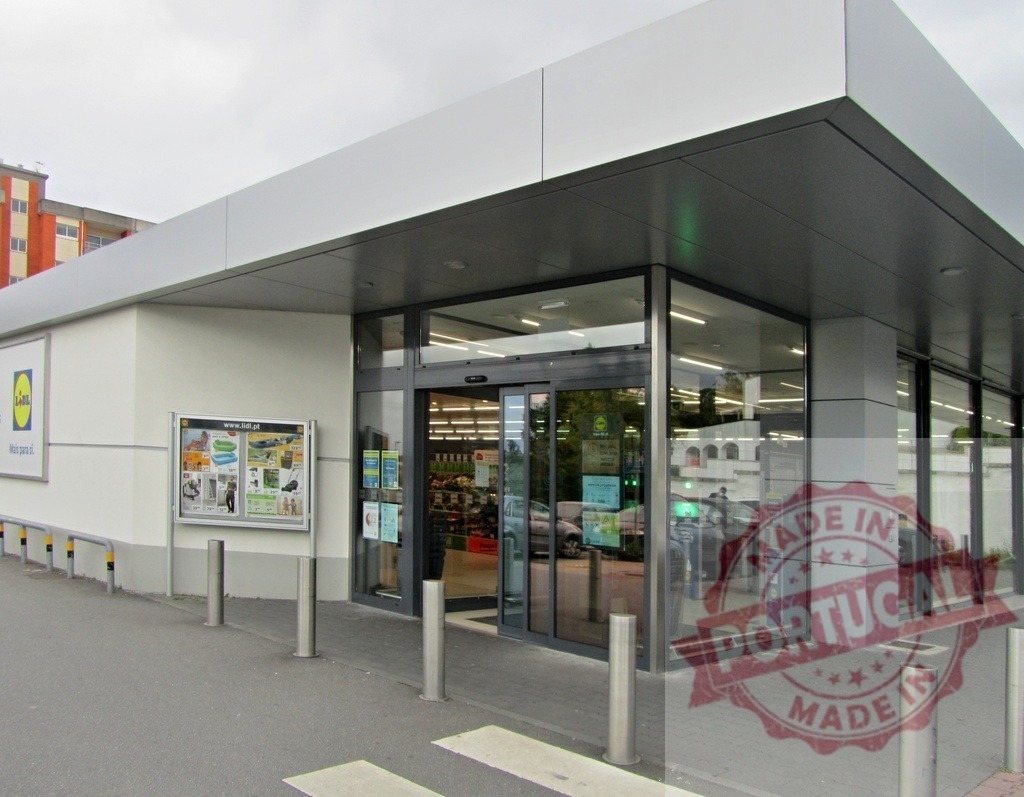 Lidl supermarket building with automatic glass doors and entrance | Lidl supermarket building exterior with modern automatic glass doors and signage - Realisiert mit Pictrs.com