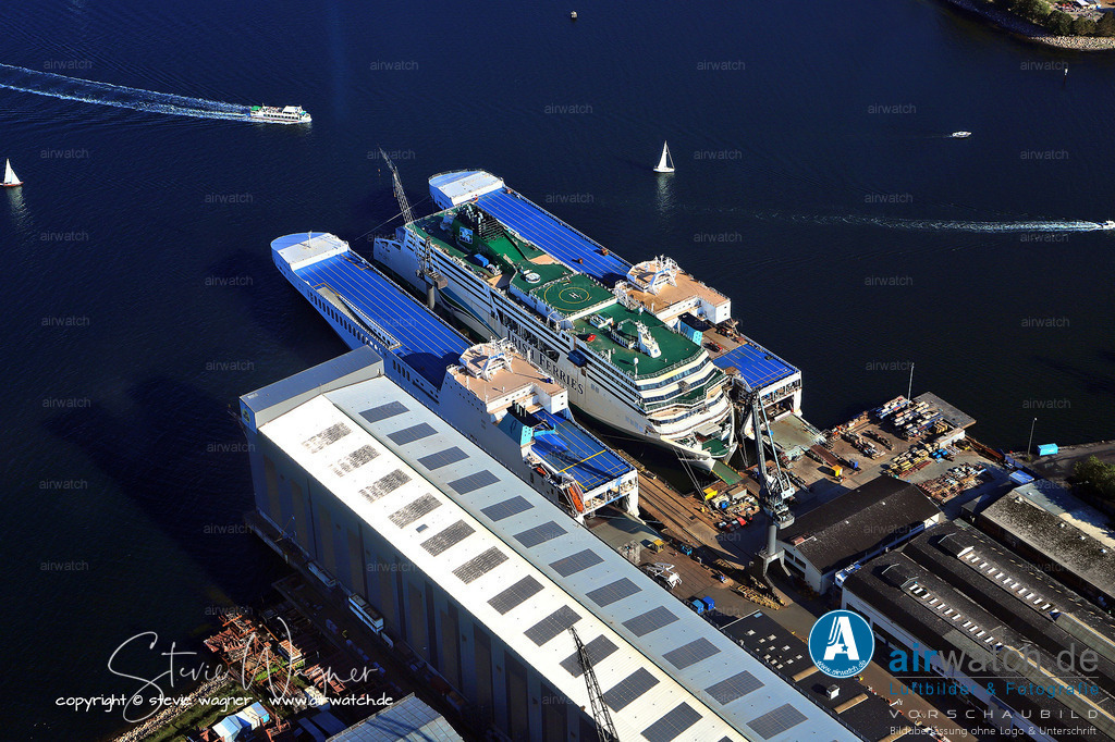 Luftbild, Flensburger Foerde, Flensburger Schiffbau Gesellschaft, FSG | Die Fähre W.B. Yeats ist eine Ro-Pax-Fähre (Passagier- und Autofähre) der irischen Reederei Irish Ferries, die von der Flensburger Schiffbau-Gesellschaft (FSG) im Jahr 2018 gebaut wurde und am 19. Januar 2018 getauft wurde. Sie wurde am 12. Dezember 2018 an Irish Ferries abgeliefert und am 22. Januar 2019 auf der Strecke Dublin–Holyhead in Dienst gestellt. Das Schiff hat eine Länge von 195 Metern und eine Breite von 32 Metern und ist mit einer Bruttoregistertonnenzahl (GRT) von 51.388 belegt. Es verfügt über eine maximale Geschwindigkeit von 23 Knoten (ca. 43 km/h) und ist mit vier Caterpillar-Dieselmotoren (Typ 8M43(C)) angetrieben, die eine Gesamtleistung von 33,6 MW (ca. 45.058 PS) erzeugen