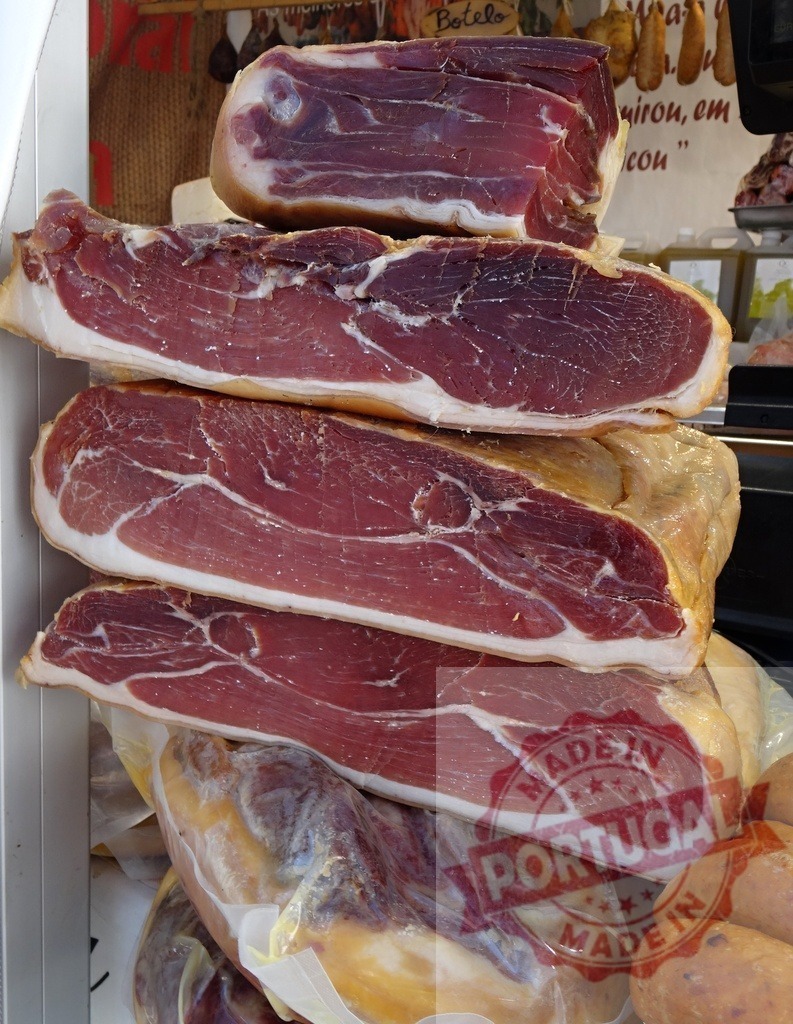 Cured meat prosciutto ham ready for sale | Slices of cured prosciutto ham displaying texture, fat, and meat in a market - Realisiert mit Pictrs.com