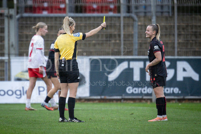 Frauen Fußball-Bundesliga; Bayer 04 Leverkusen - RB Leipzig, 06.12.2025 | Schiedsrichterin Julia Boike (Altenstadt) zeigt Vanessa Fudalla (Bayer 04 Leverkusen, 21) die gelbe Karte; Bayer 04 Leverkusen - RB Leipzig an Spieltag 12 der Google Pixel Frauen-Bundesliga am 06.12.2025 im Ulrich-Haberland-Stadion in Leverkusen (Nordrhein-Westfalen). DFL REGULATIONS PROHIBIT ANY USE OF PHOTOGRAPHS AS IMAGE SEQUENCES AND/OR QUASI-VIDEO.