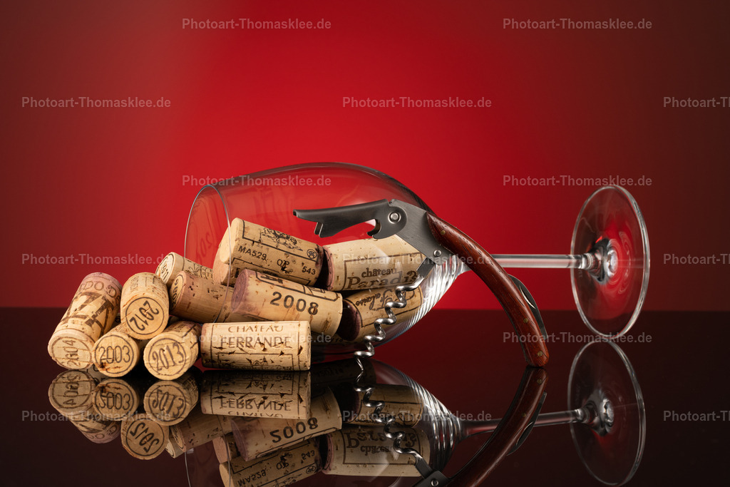 Vintage Weinkorken Sammlung - Edle Rot-Braun Komposition | Ein stimmungsvolles Arrangement aus Naturkorken verschiedener Weingüter bildet den Mittelpunkt dieser edlen Fotografie. Der klassische Korkenzieher mit Holzgriff und das kristallklare Weinglas ergänzen die Szene perfekt. Die warme rötliche Beleuchtung verleiht dem Bild eine intime Weinstube-Atmosphäre. Reflektionen auf der glatten Oberfläche schaffen zusätzliche Tiefe und Eleganz. Diese Komposition spricht jeden Weinkenner an und eignet sich hervorragend als stilvolle Küchen- oder Esszimmerdekoration. - Realisiert mit Pictrs.com