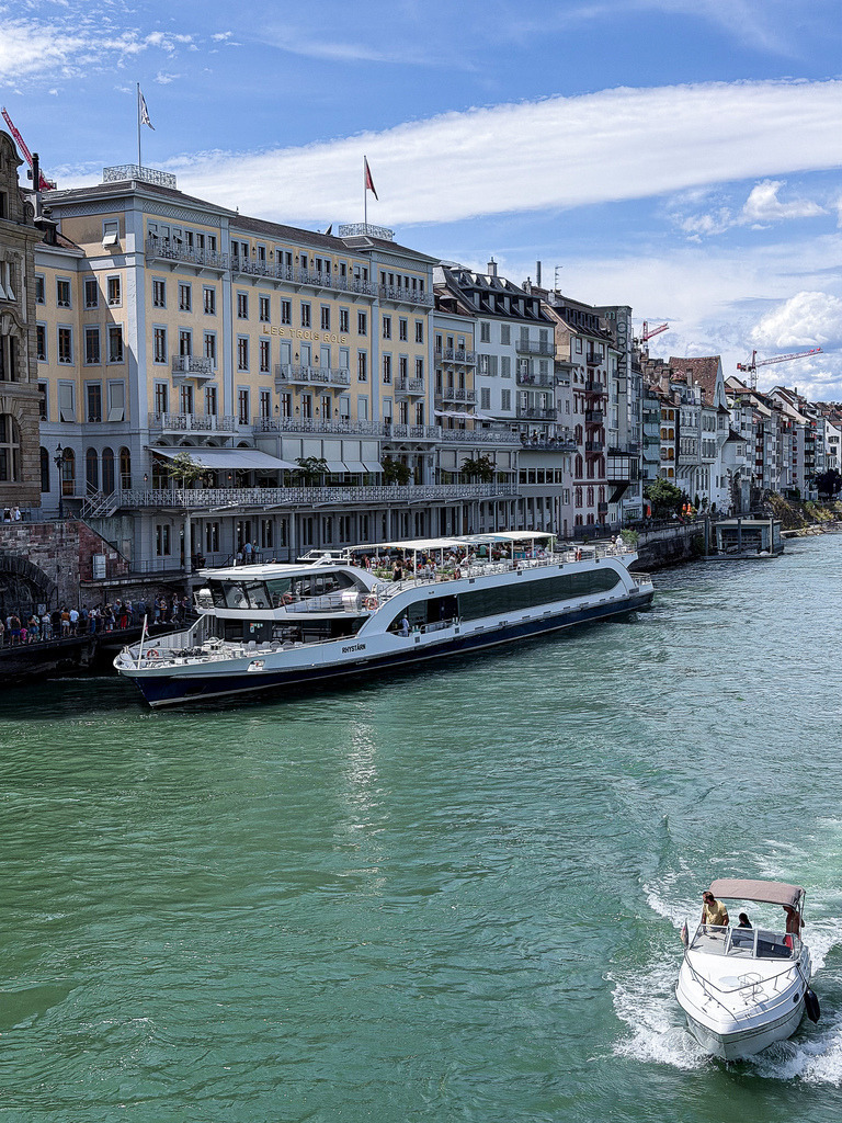 Rheinromantik Basel – Moderne Architekturfotografie Schifflände | Urbane Dynamik am Basler Rheinufer. Diese gestochen scharfe Fine-Art-Fotografie fängt die pulsierende Atmosphäre an der historischen Schifflände in Basel ein. Der faszinierende Kontrast zwischen den detailreichen Fassaden der Altstadt, den eleganten Schiffen und dem weiten, blauen Himmel macht dieses Werk zu einer stilvollen Liebeserklärung an die Stadt am Rhein. Ein exklusiver Blickfang für moderne Wohnräume, Büros oder Kanzleien im Dreiländereck. Optimal als großformatiger Galerie-Druck unter Acrylglas. - Realisiert mit Pictrs.com