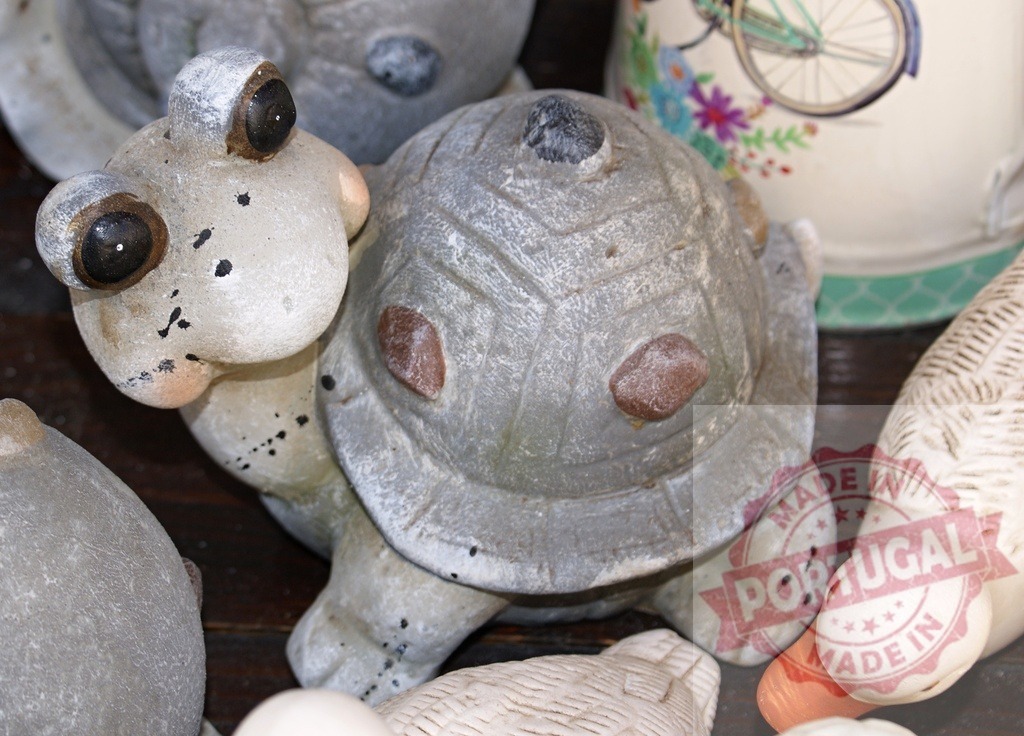 Stone turtle figurine standing among other garden ornaments | Stone turtle figurine decorating a garden ornament collection - Realisiert mit Pictrs.com