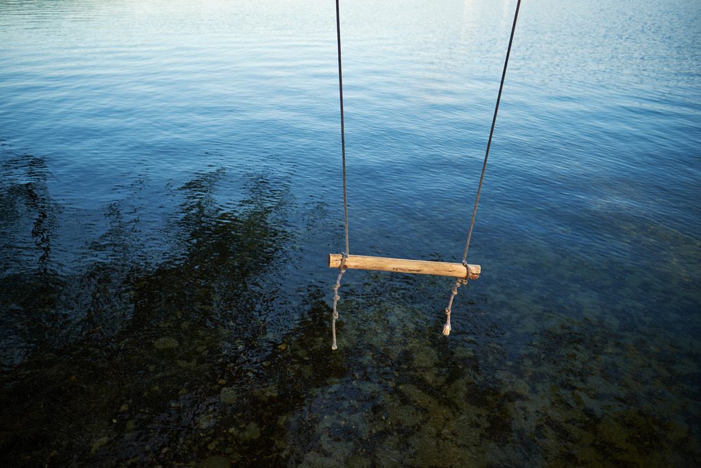 Schaukel über dem Wasserspiegel | Hard, Vorarlberg - May 26, 2022: Schaukel über dem Wasserspiegel. - Realisiert mit Pictrs.com