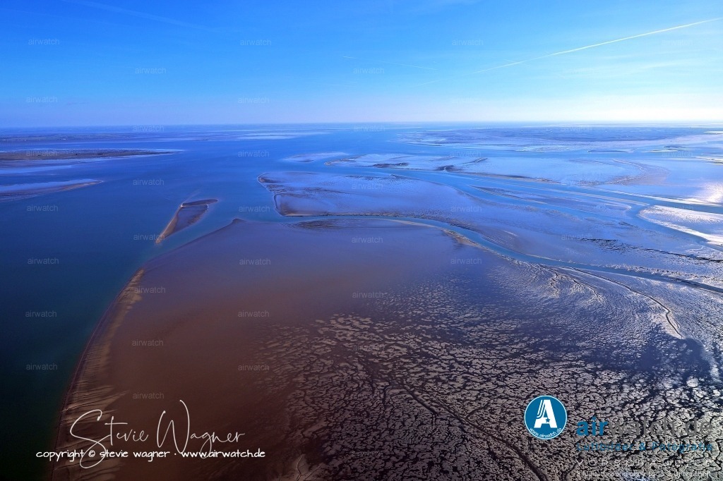 Fahrrinne und Priele - Hamburger Hallig - Pellworm - Hallig Gröde | Fahrrinne und Priele zwischen Hamburger Hallig und Hallig Gröde im Hintergrund Nordstrandischmoor, Eiderstedt und Pellworm - Priele, die tiefen Gezeitenrinnen, liegen heute bei Niedrigwasser zwischen den Halligen und Inseln und sind ein charakteristisches Merkmal der Landschaft. Sie entstanden durch die ständigen Veränderungen der Küste, insbesondere durch die großen Sturmfluten im Jahr 1362 und 1634, die das ursprüngliche Land, darunter auch die Region um Rungholt, veränderten und zerstörten.