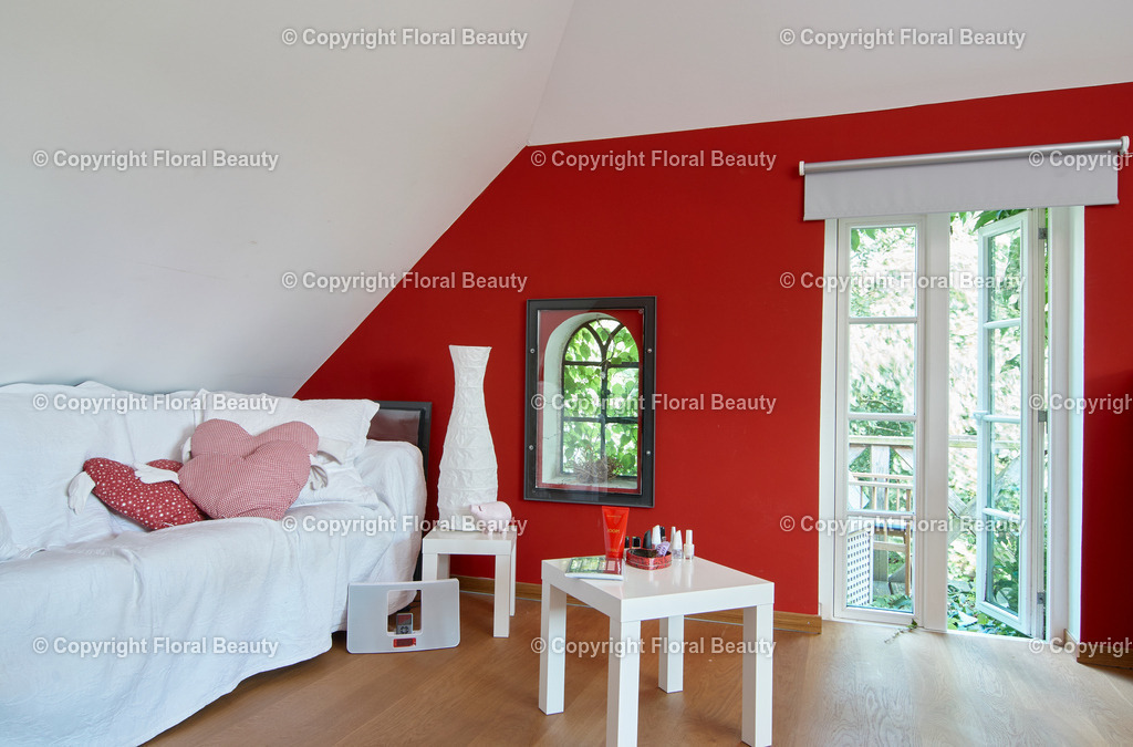 Haus am See | Kinderzimmer mit weißem Sofa und Lacktischchen. Rote Wandfarbe. - Realisiert mit Pictrs.com