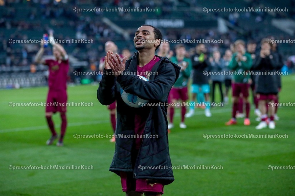 BMG21022502207 | 22.02.2025, Fußball, Borussia Mönchengladbach - FC Augsburg, 1. Fußball Bundesliga, Borussia-Park, Saison 2024 2025: Alexis Claude-Maurice (FC Augsburg #20) sichert sich nach dem Hattrick den SpielballDFB regulations prohibit any use of photographs as image sequences and or quasi-video.
