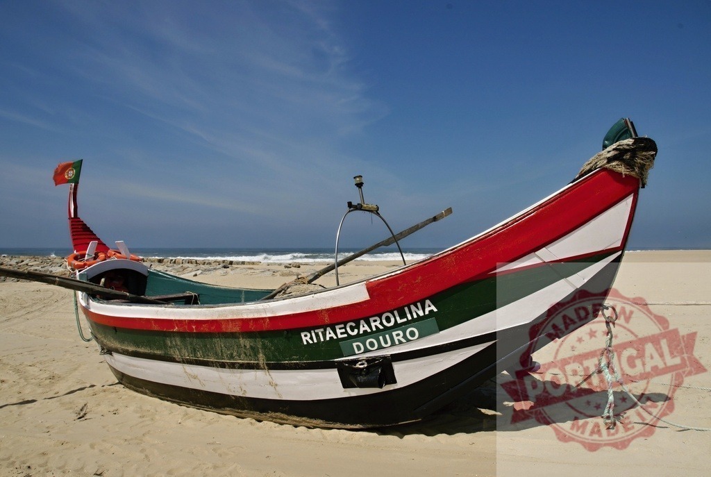 Traditional Portuguese fishing boat on sandy beach | Fishing boat RITAE CAROLINA DOURO standing on a sandy beach under a blue sky - Realized with Pictrs.com