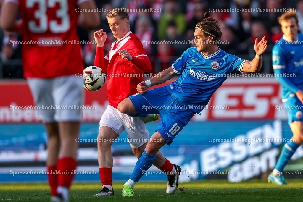 RWE06042501107 | 2025.04.06, Fußball, 3.Liga, Rot-Weiss Essen - FC Hansa Rostock, Stadion Hafenstraße, Saison 2024 2025: Julian Eitschberger (RWE #2) im Zweikampf gegen Sigurd Haugen (FC Hansa Rostock #18) DFB regulations prohibit any use of photographs as image sequences and or quasi-video.