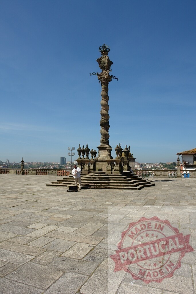 Pelourinho da Sé column in Porto Portugal. Porto - Portugal | Pelourinho da Sé column standing over old city rooftops against a clear blue sky - Realized with Pictrs.com