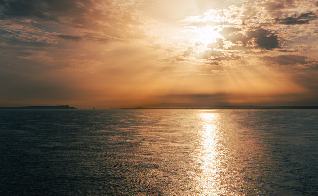Fantastischer stimmungsvoller Sonnenuntergang-----Portland | Die Aufnahme zeigt den Blick von oder auf die Halbinsel Portland an der Südküste Englands. Die Region ist Teil der berühmten Jurassic Coast und bekannt für ihre dramatischen Küstenlinien, das historische Portland Bill Lighthouse sowie den kilometerlangen Kieselstrand Chesil Beach, an dem das Meer im Abendlicht genau dieses goldene Farbenspiel widerspiegelt.Möchten Sie mehr über die Isle of Portland erfahren oder suchen Sie nach weiteren Aufnahmen dieser Küstenregion? - Realisiert mit Pictrs.com