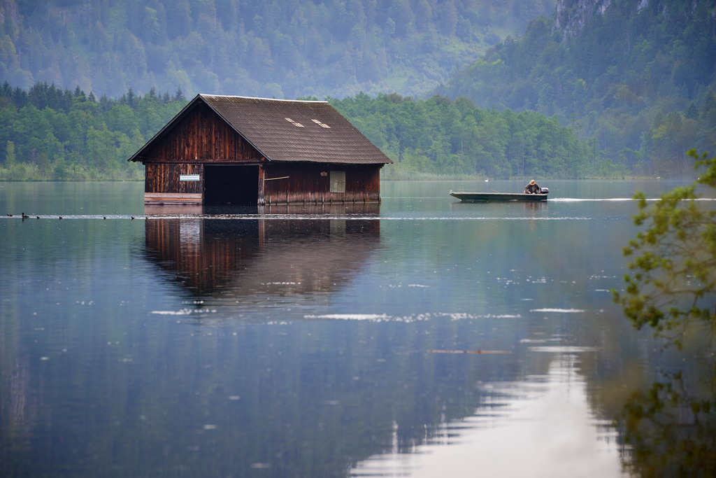 Fischerhuette und Boot mit Fischer | Gruenau im Almtal, Austria - July 22, 2016: Fischerhuette und Boot mit Fischer am frühen Morgen. - Realisiert mit Pictrs.com