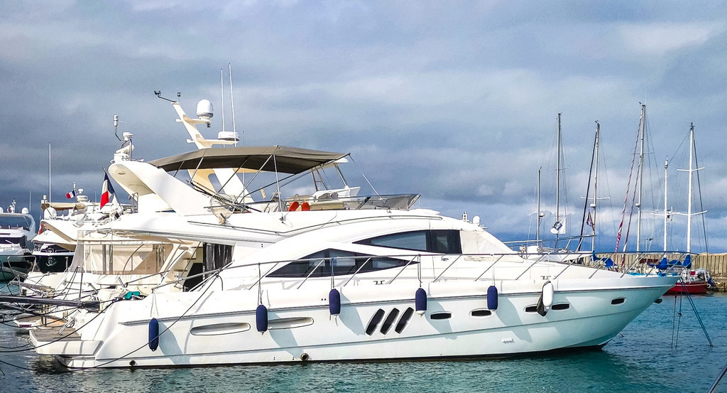 Wandbild Kunstdruck Poster – Yacht in Antibes: Elegante Sealine T60 an der Côte d'Azur von Robert Steinke | Hol dir das unbeschwerte Lebensgefühl der französischen Riviera und die pure Exklusivität des maritimen Lifestyles direkt an deine Wand. Diese High-End-Fotografie fängt eine elegante Sealine T60 Flybridge-Motoryacht im Hafen von Antibes ein. Diese Luxusyacht der Spitzenklasse zeichnet sich durch ihr markantes, dynamisches Flybridge-Design, eine großzügige Deckaufteilung sowie technische Highlights wie ein ausziehbares Cockpitsystem und drei luxuriöse Kabinen aus. Das strahlende Weiß des edlen Schiffsrumpfs kontrastiert perfekt mit dem ruhigen, tiefblauen Meerwasser unter klarem Sommerhimmel – ein maritimes Meisterwerk, das Freiheit und Eleganz in Perfektion verkörpert.Dieses luxuriöse und moderne Kunstwerk ist der perfekte, repräsentative Blickfang für ein stilvolles Büro, das moderne Wohnzimmer, ein exklusives Design-Loft oder für eine erfrischende Urlaubsstimmung im Flur und Schlafzimmer.Um das strahlende Weiß der Flybridge-Yacht und die enorme Leuchtkraft des mediterranen Blaus perfekt zur Geltung zu bringen, empfehle ich den Druck auf unseren Premium-Materialien: Erlebe kinoreife Tiefe und maximalen Glanz auf edlem Acrylglas, hochmoderne Eleganz auf robustem Alu-Dibond oder klassischen Galerie-Charakter auf einer matten Leinwand. Bring exklusiven Yacht-Lifestyle an deine Wand! - Realisiert mit Pictrs.com