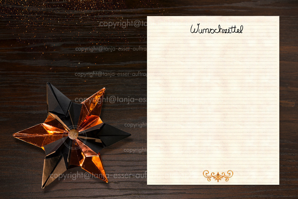 Christmas wishlist on decorated table, German text means: Wishlist | Weihnachtswunschzettel auf dekoriertem Tisch, deutscher Text bedeutet: Wunschzettel