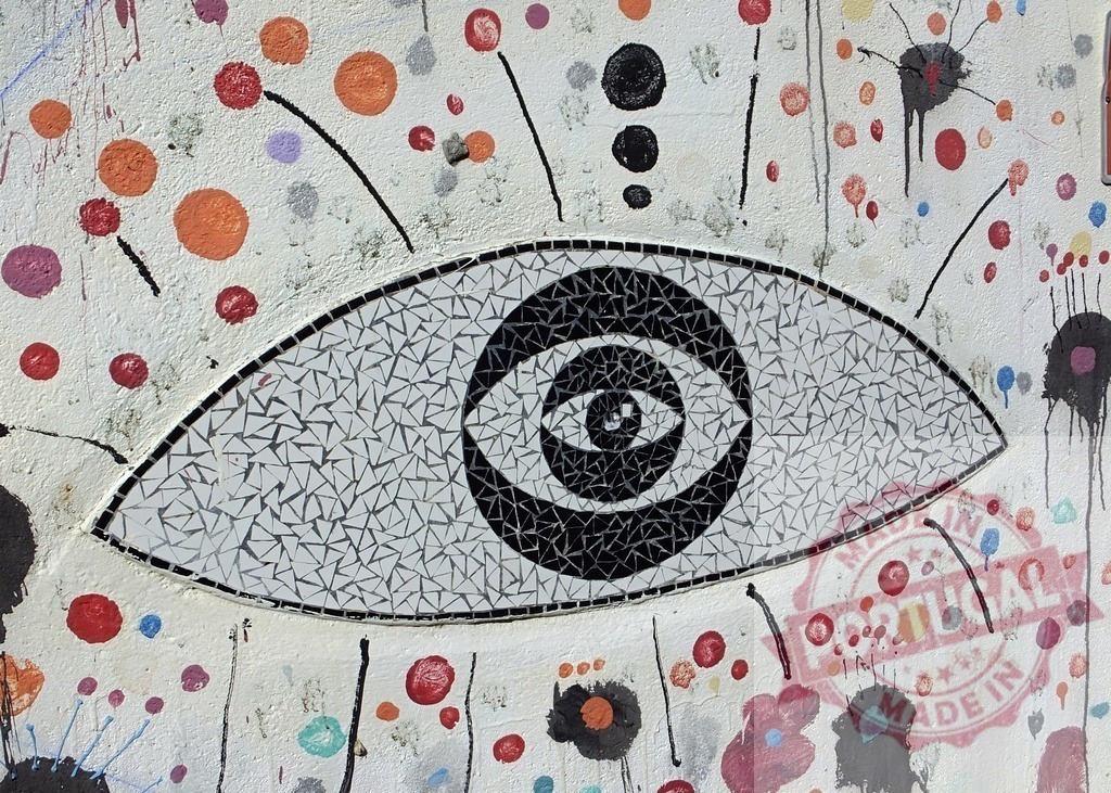 Colorful wall featuring mosaic eye street art | Mosaic eye with abstract colorful dots and paint splatters on a textured urban wall - Realisiert mit Pictrs.com