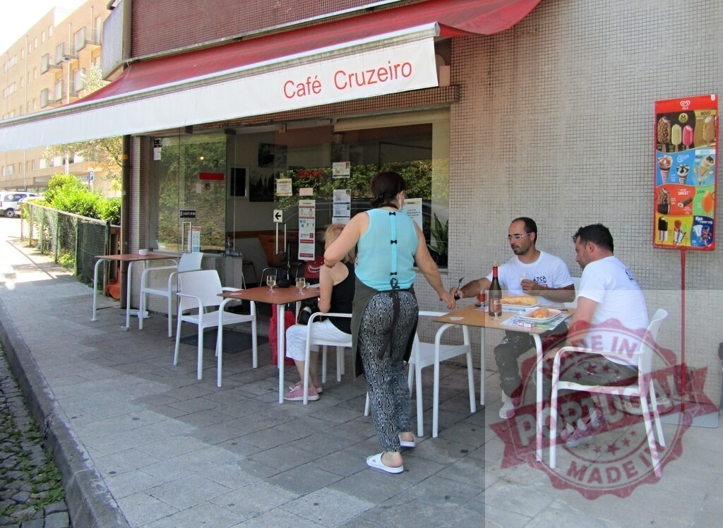 Waitress serving customers at outdoor Café Cruzeiro | Waitress serving men enjoying beer and meal at outdoor sidewalk cafe - Realized with Pictrs.com