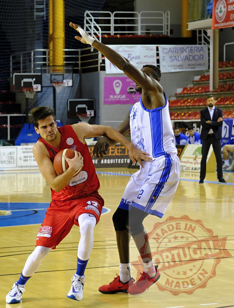 Basketball player dribbling ball defending opponent | Basketball players competing on an indoor court during a game - Realisiert mit Pictrs.com