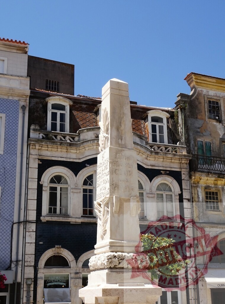 Aveiro liberal monument obelisk in Portugal plaza | Obelisk monument standing in a historic plaza with traditional buildings under a clear sky - Realisiert mit Pictrs.com