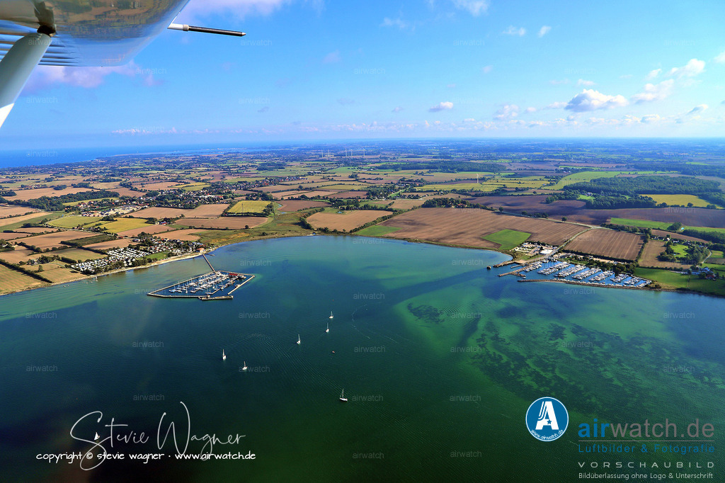 Luftbild Wackerballig und Gelting Mole - Die Flensburger Förde ist ein bedeutendes Naturschutzgebiet | Die Flensburger Förde ist ein bedeutendes Naturschutzgebiet und beherbergt eine reiche Tier- und Pflanzenwelt, darunter seltene Vogelarten. Sie ist auch ein beliebtes Revier für verschiedene Wassersportarten: Segler schätzen die oft starken Winde, die ein ideales Segelrevier schaffen, während Surfer die flachen Gewässer der Außenförde und der Innenförde nutzen. Taucher finden hier Wracks und künstliche Riffe, die die Ostseefauna fördern. Zudem gilt die Förde als erstklassiges Angelrevier, insbesondere für Meerforellen, deren Haupt-Angelsaison von September bis April reicht.