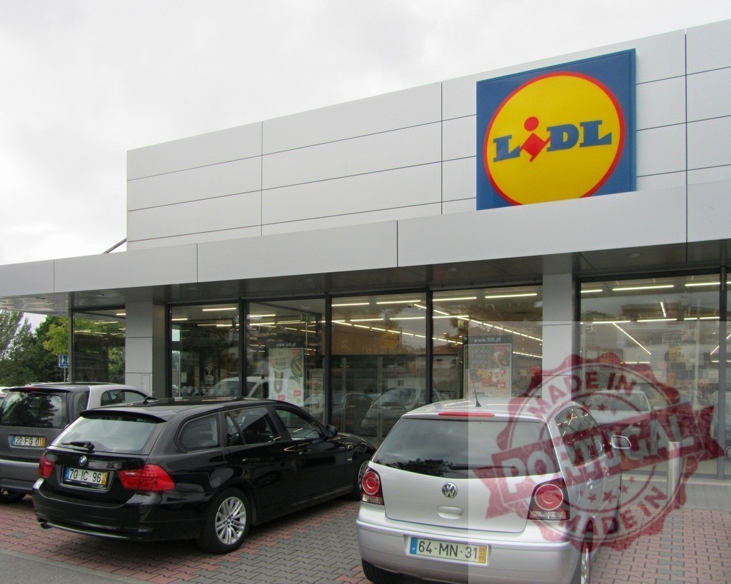 Lidl supermarket building with cars parked outside | Lidl supermarket exterior facade and parking lot with vehicles parked - Realized with Pictrs.com