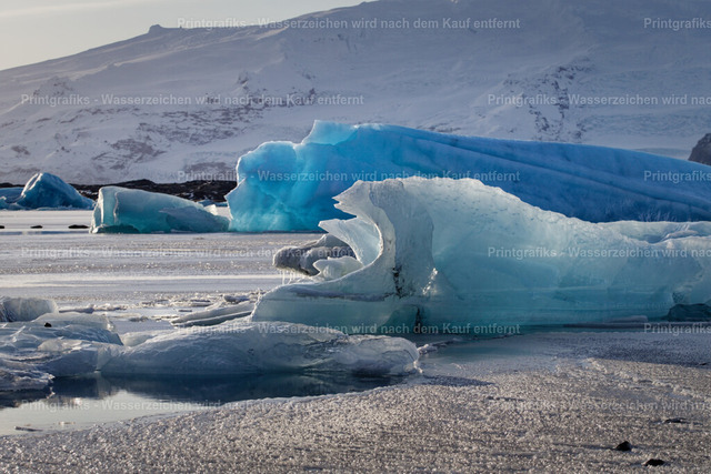 Blaues Eis in der Gletscherlagune | Leuchtend blaue Eisberge treiben in einer winterlichen Gletscherlagune in Island. Die klaren Eisstrukturen, das kalte Licht und die stille Wasserfläche erzeugen eine ruhige, faszinierende Atmosphäre nordischer Natur. - Realisiert mit Pictrs.com