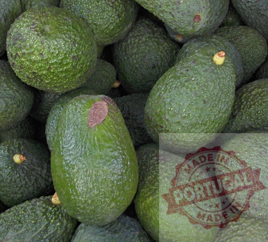 Fresh green avocados piled at market stall | Avocados showing textured green skin and ready for sale - Realized with Pictrs.com