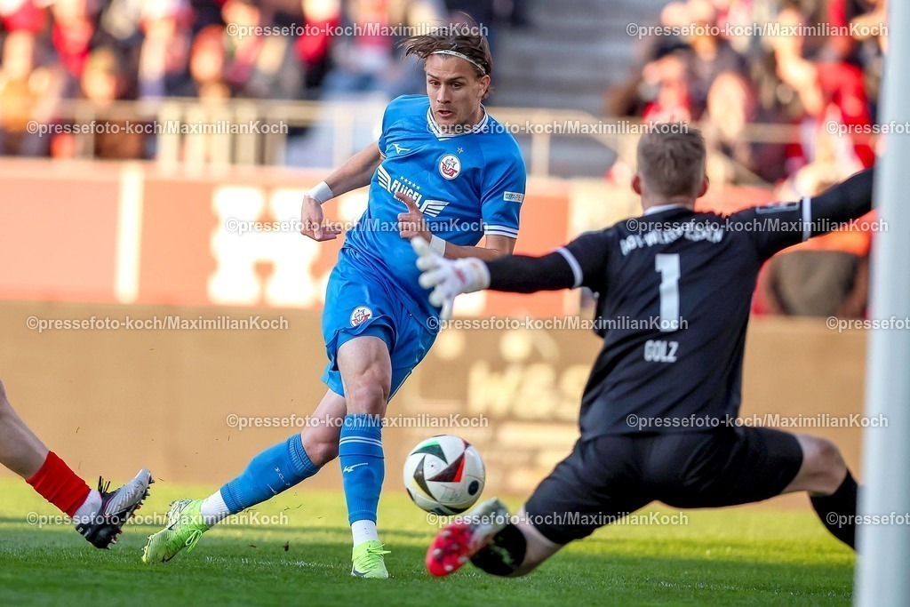 RWE06042501024 | 2025.04.06, Fußball, 3.Liga, Rot-Weiss Essen - FC Hansa Rostock, Stadion Hafenstraße, Saison 2024 2025: Sigurd Haugen (FC Hansa Rostock #18) Schuss auf das Tor von Torwart Jakob Golz (RWE #1) DFB regulations prohibit any use of photographs as image sequences and or quasi-video.