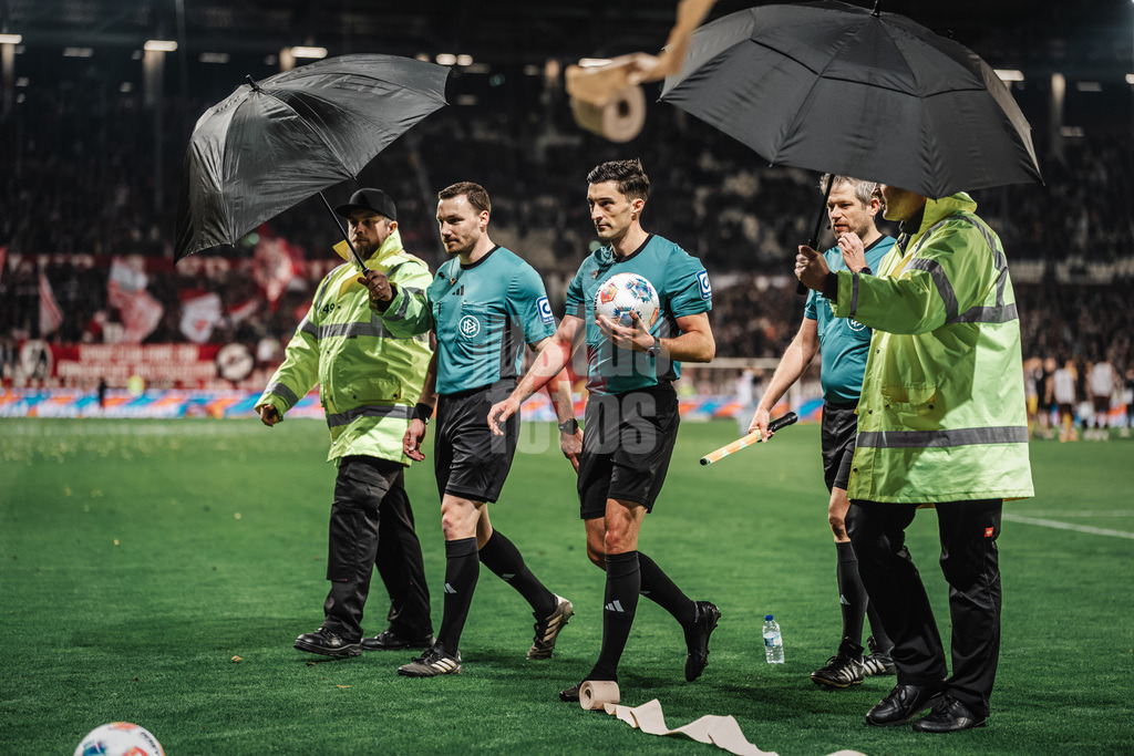 Fußball | Männer | Saison 2025/2026  | Fußball-Bundesliga | 27. Spieltag | FC St. Pauli vs. SC Freiburg | 22.04.2026 | Klopapiert wird auf die Schiedsrichter v.l. Philipp Hüwe, Florian Brandstübner und Markus Schüller geworfen Regenschirm Eskort aus dem Stadion heraus