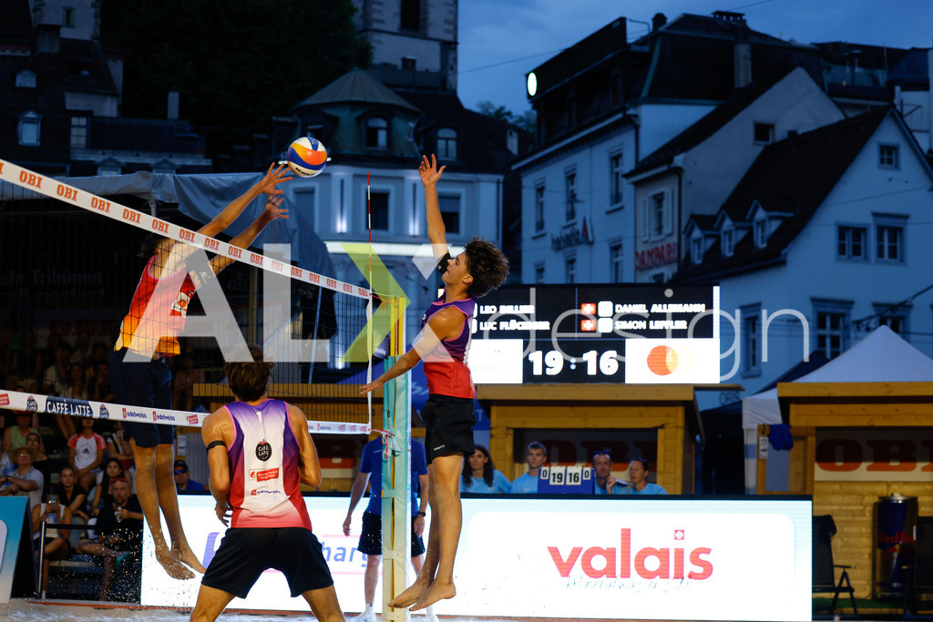 Obi BeachTour 2026 - Basel | BASEL, SWITZERLAND - JULY 17: LUC EMANUEL FLÜCKIGER (SUI) attack / spike against SIMON LEFFLER (SUI) block during the Obi BeachTour 2026 match between DILLIER / FLÜCKIGER (SUI) and ALLEMANN / LEFFLER (SUI) at Barfüsserplatz on July 17, 2026 in Basel, Switzerland. - Realisiert mit Pictrs.com