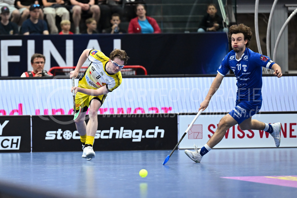 Zug United - HC Rychenberg - 25. April 2026 | Kimo Oesch (#9 HC Rychenberg Winterthur) spielt den Ball ab, bevor er von Linus Arnold (#11 Zug United) angegriffen wird am L-UPL Superfinal-Spiel zwischen Zug United und HC Rychenberg am 25. April 2026 in der BCF Arena, Fribourg, Schweiz.Bild: Sportfotografie Markus Aeschimann | www.markus-aeschimann.ch - Realisiert mit Pictrs.com