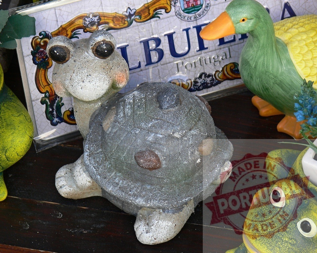 Turtle, duck, and frog garden figurines with Albufeira souvenir plaque | Stone turtle figurine with ceramic duck and frog garden ornaments in Portugal - Realized with Pictrs.com